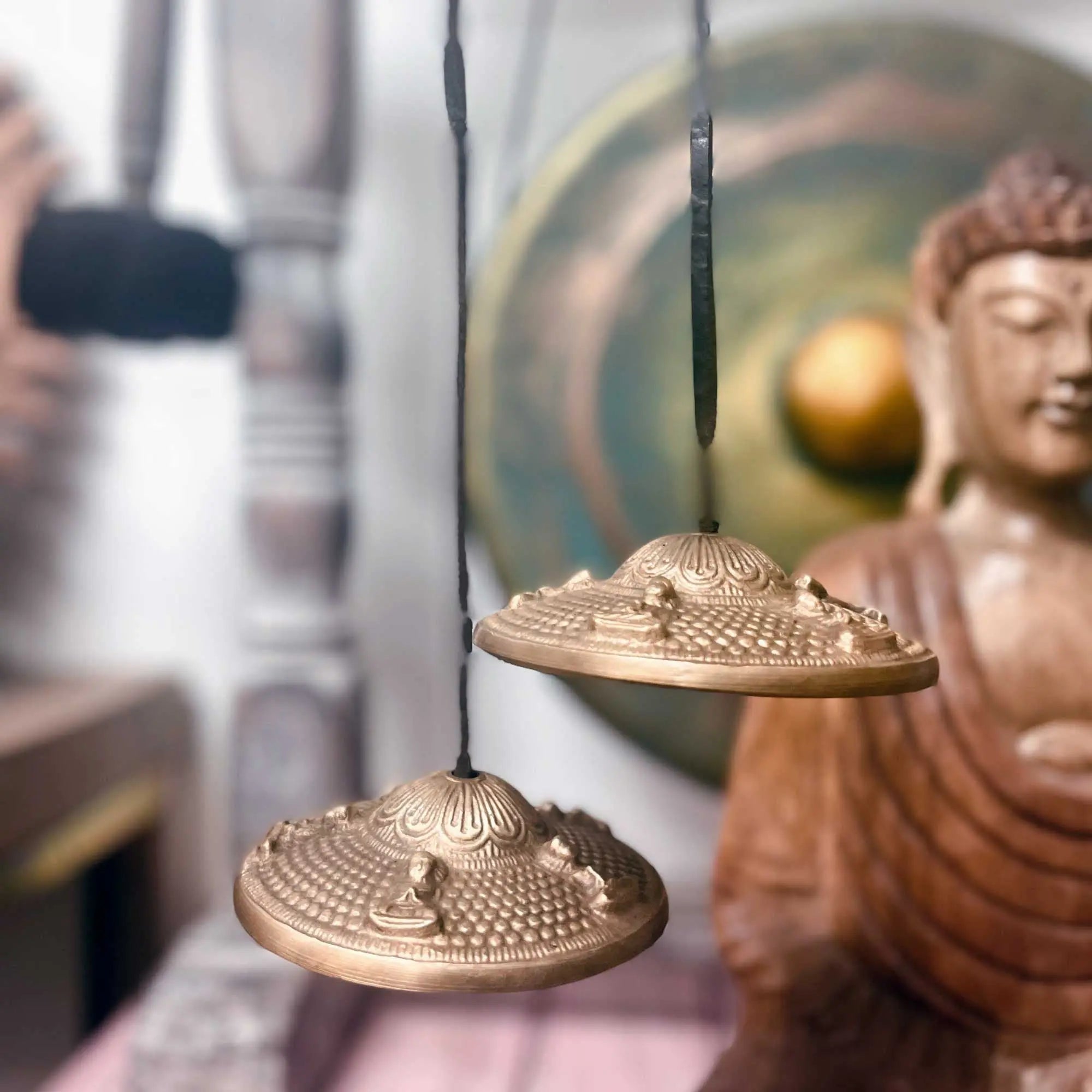 Cloche tibétaine Tingsha et statue de Bouddha dans un espace de méditation