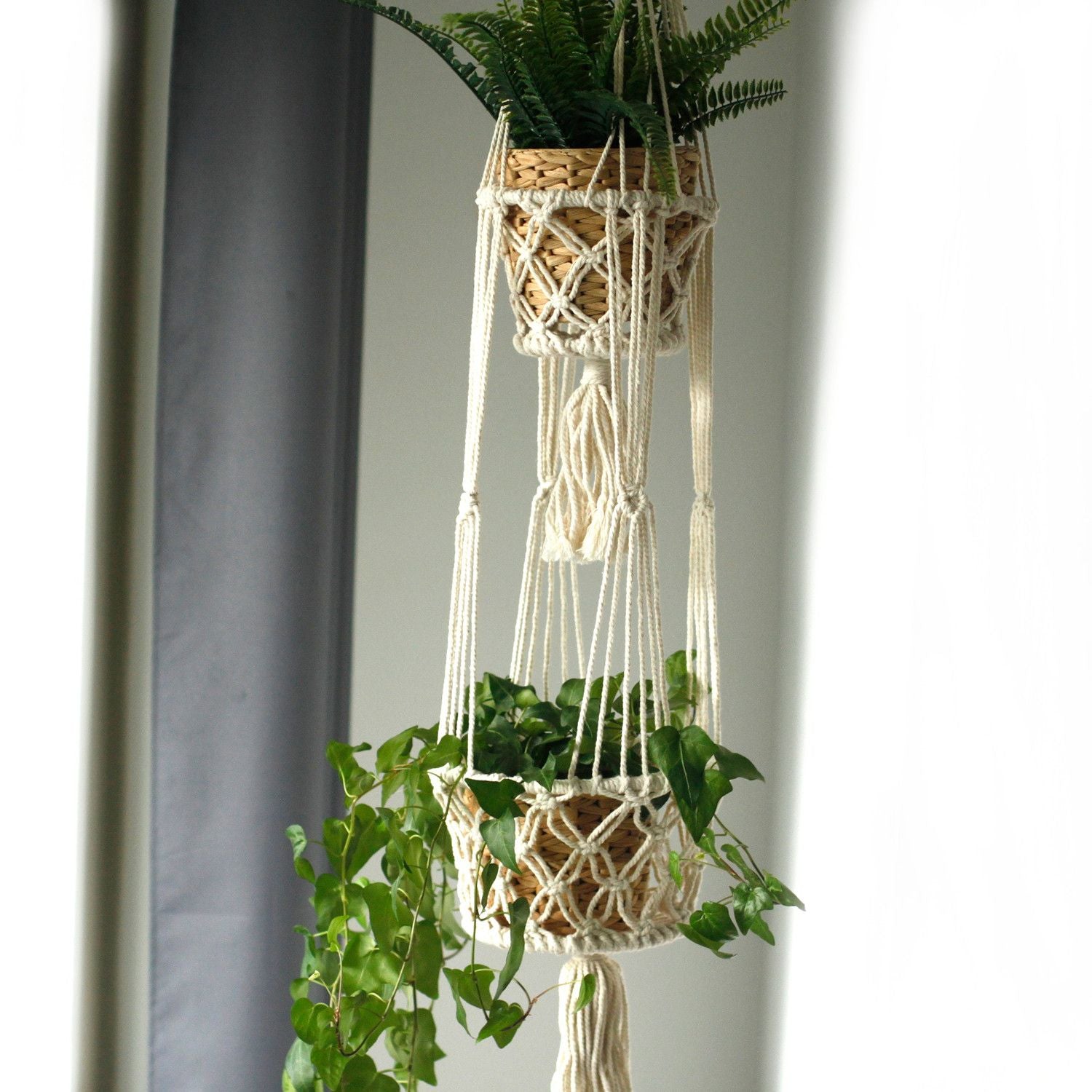 Deux pots de plantes installés dans une suspension en macramé