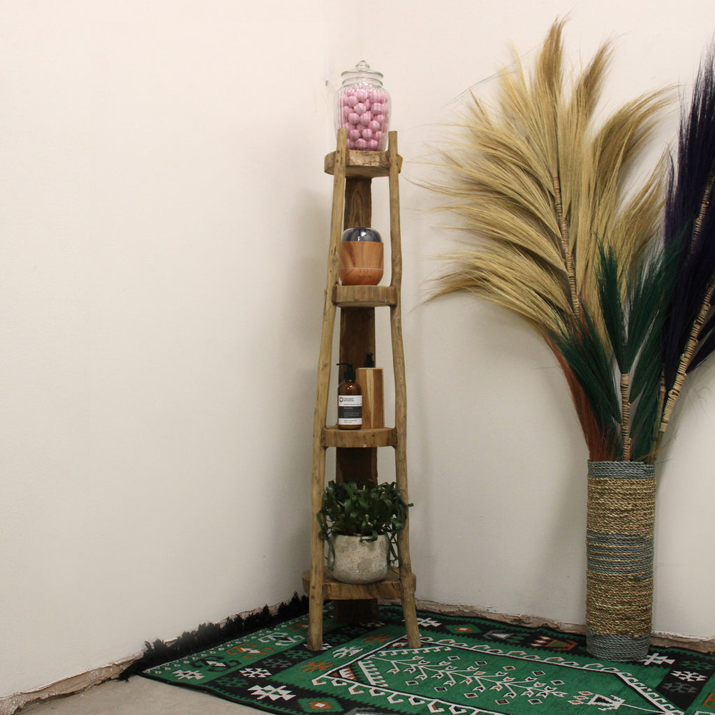 Meuble d’angle en teck naturel présenté dans un intérieur avec une plante décorative.