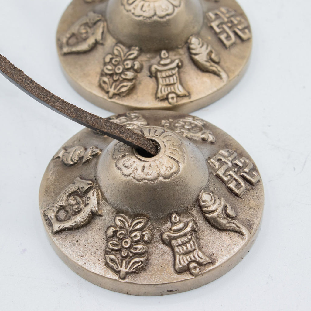 Gros plan sur les motifs porte-bonheur gravés sur les cymbales tibétaines