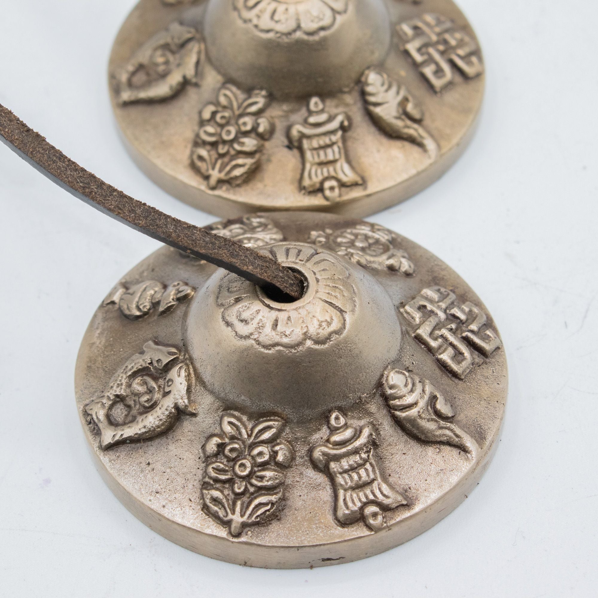 Gros plan sur les motifs porte-bonheur gravés sur les cymbales tibétaines