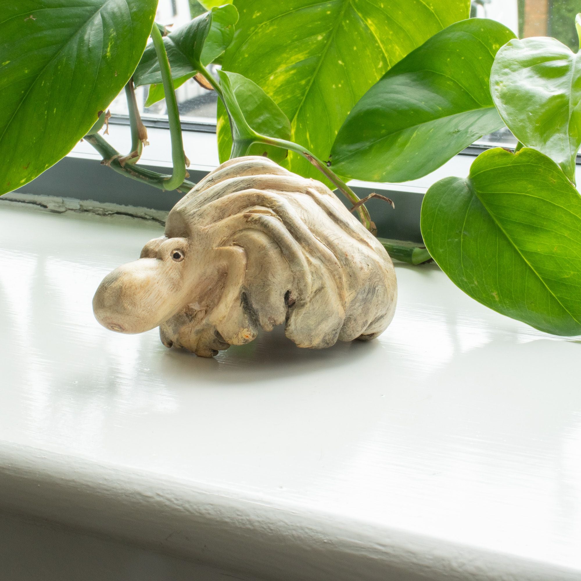 Petite pieuvre en bois parasite présentée dans une décoration végétale